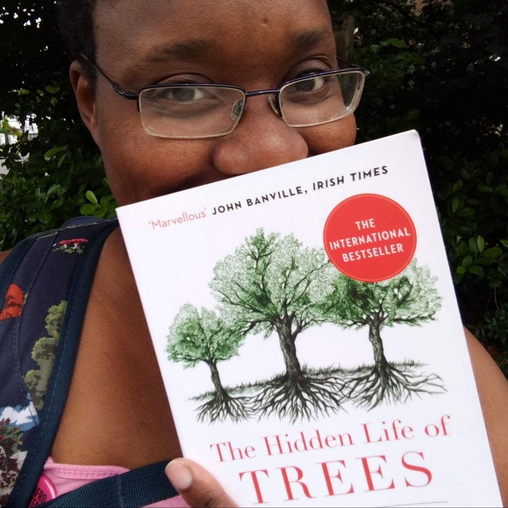 LiLi smiles behind The Hidden Life of Trees book