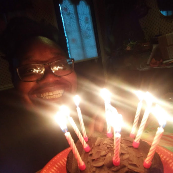 LiLi smiling near cake lit with candles